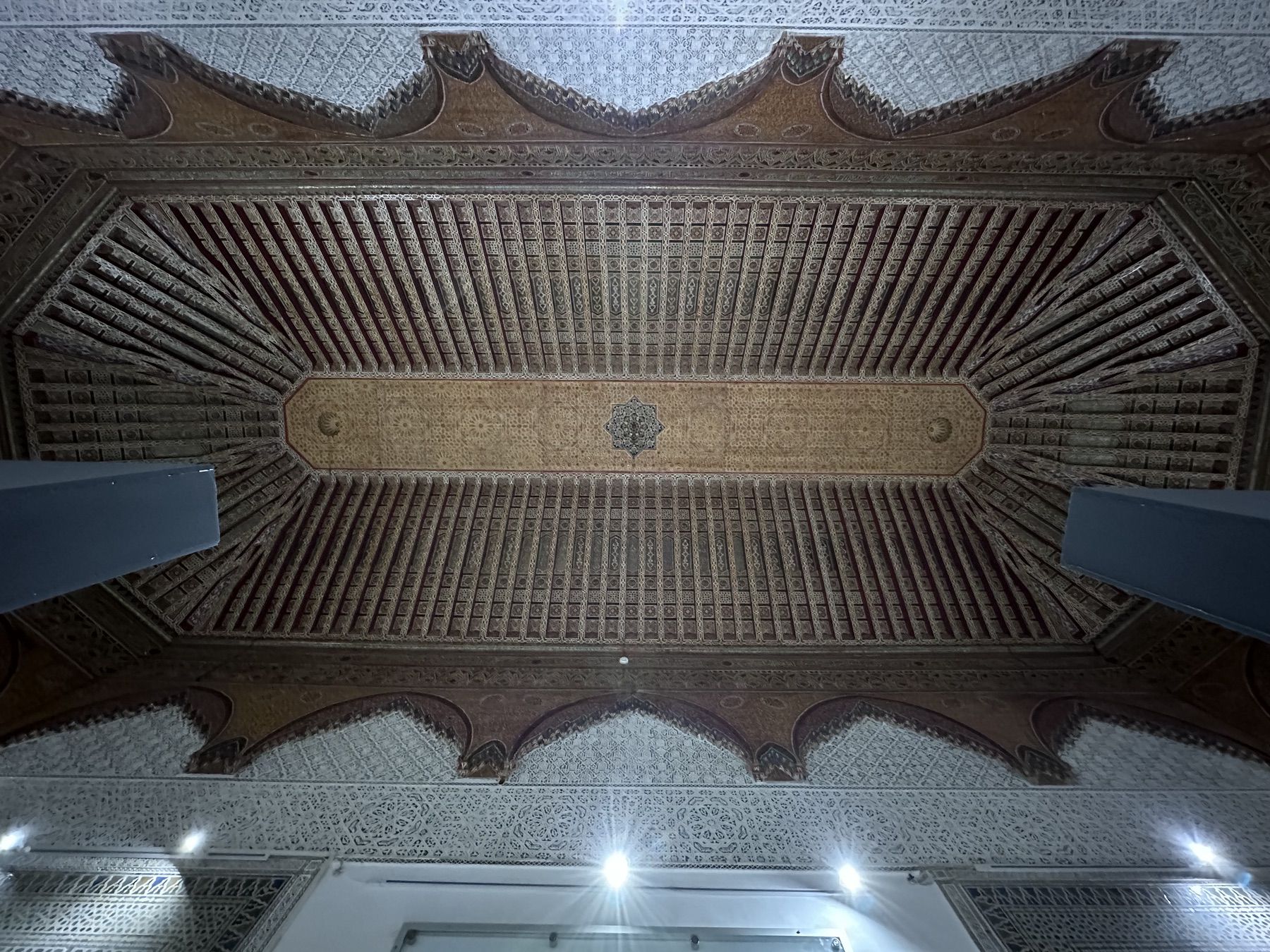 <p>Upward view of a carved, painted wood ceiling and carved stucco frame.</p>