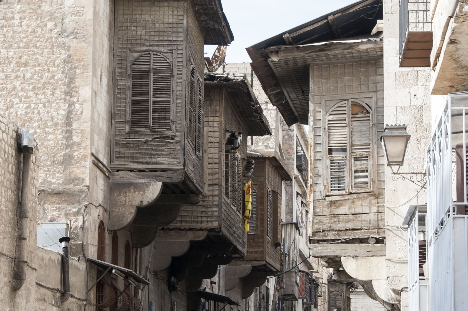 View down a street in Aleppo, Syria with overhanging wooden balconies.