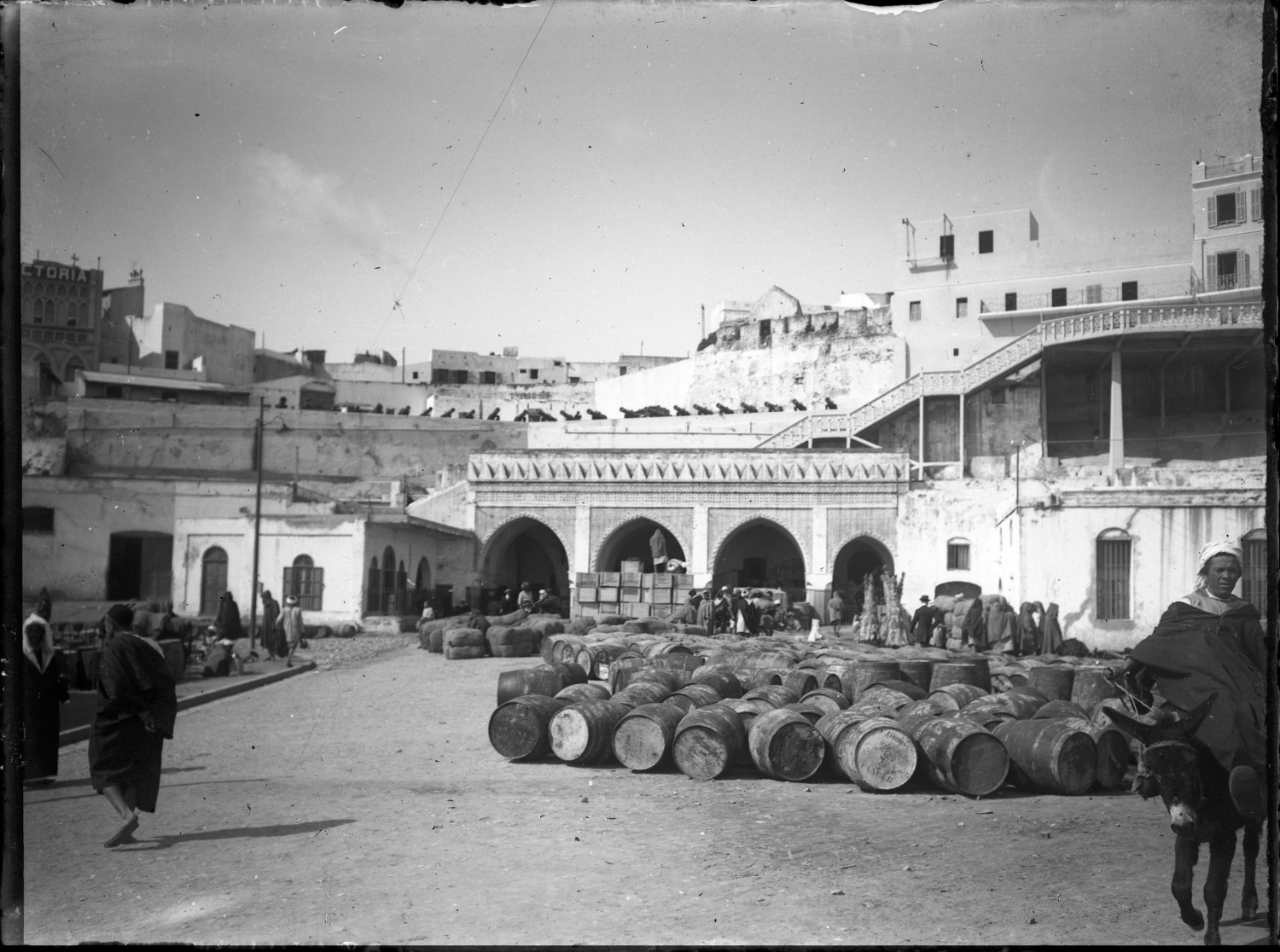 People in traditional dress and barrels at port 