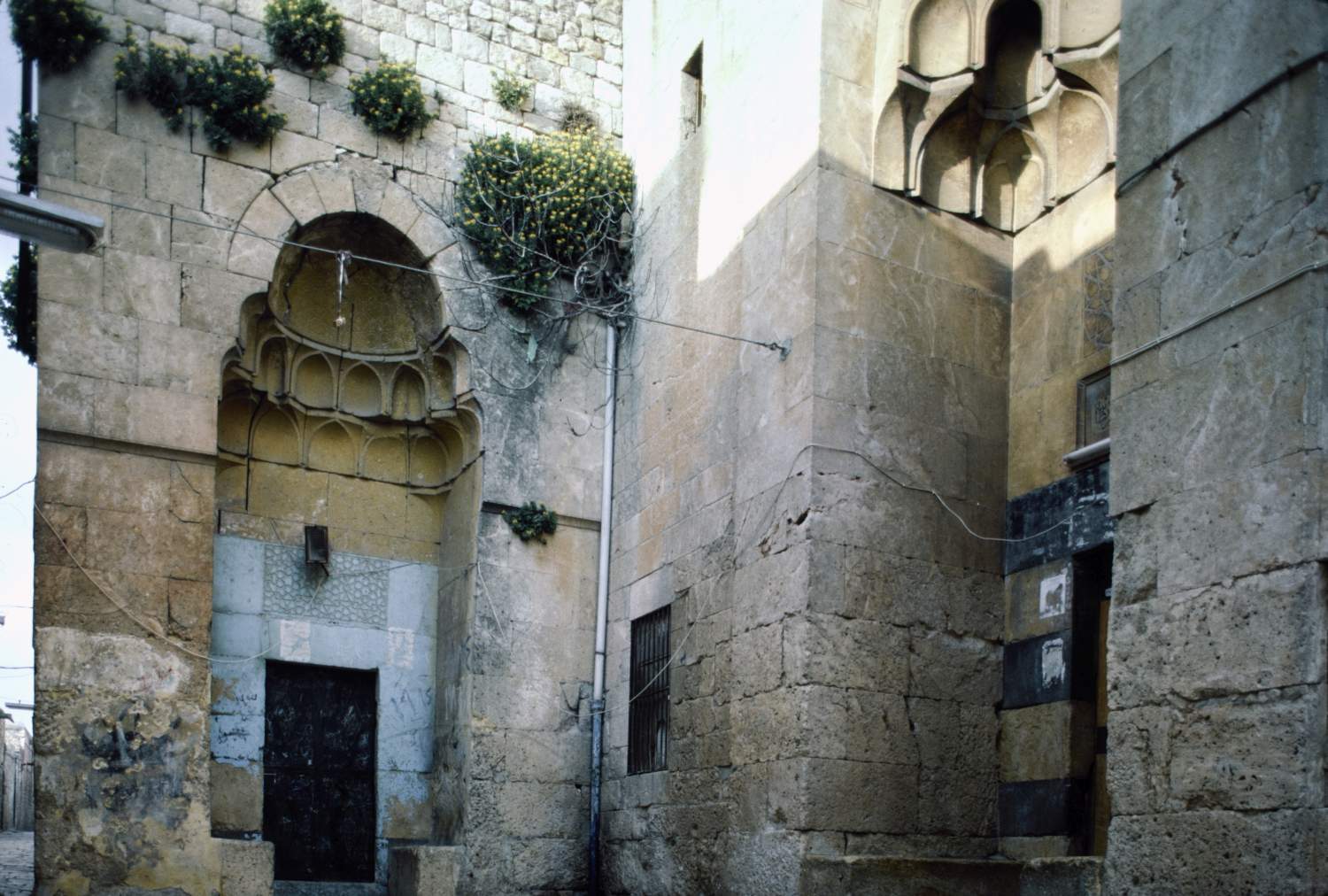 View of entrance portals, with small north portal to residential unit at left and larger entrance portal to madrasa at right.