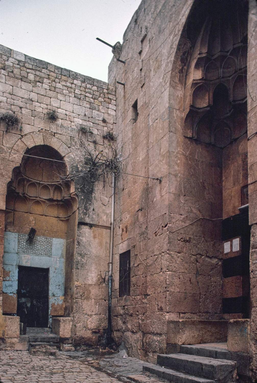 View of entrance portals, with small north portal to residential unit at left and larger entrance portal to madrasa at right.