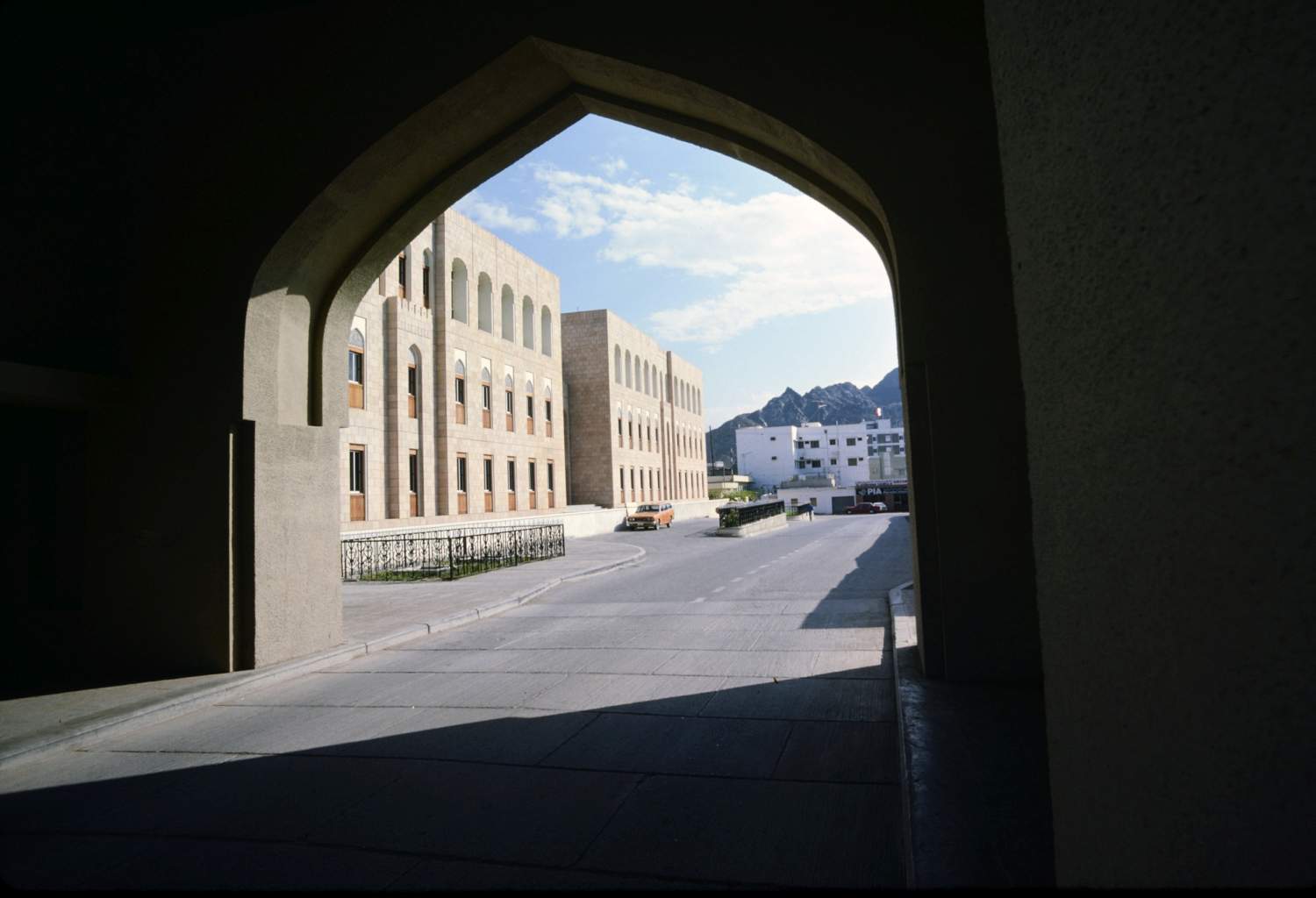 <p> View to south, through gate, along empty roadway, past part of the finance complex</p>
