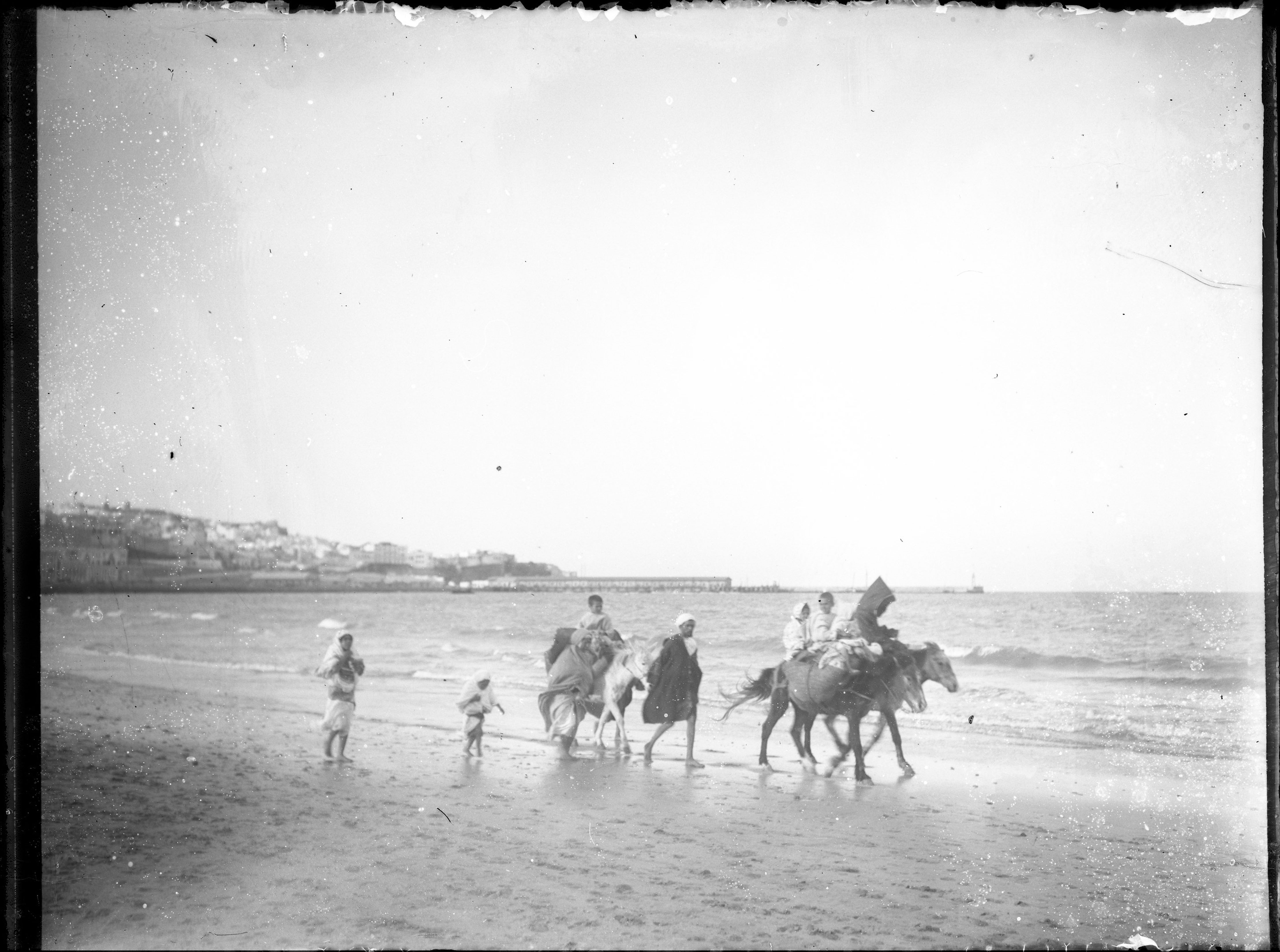 <p>A family in Moroccan dress walks along the shore outside of Tangier.</p>