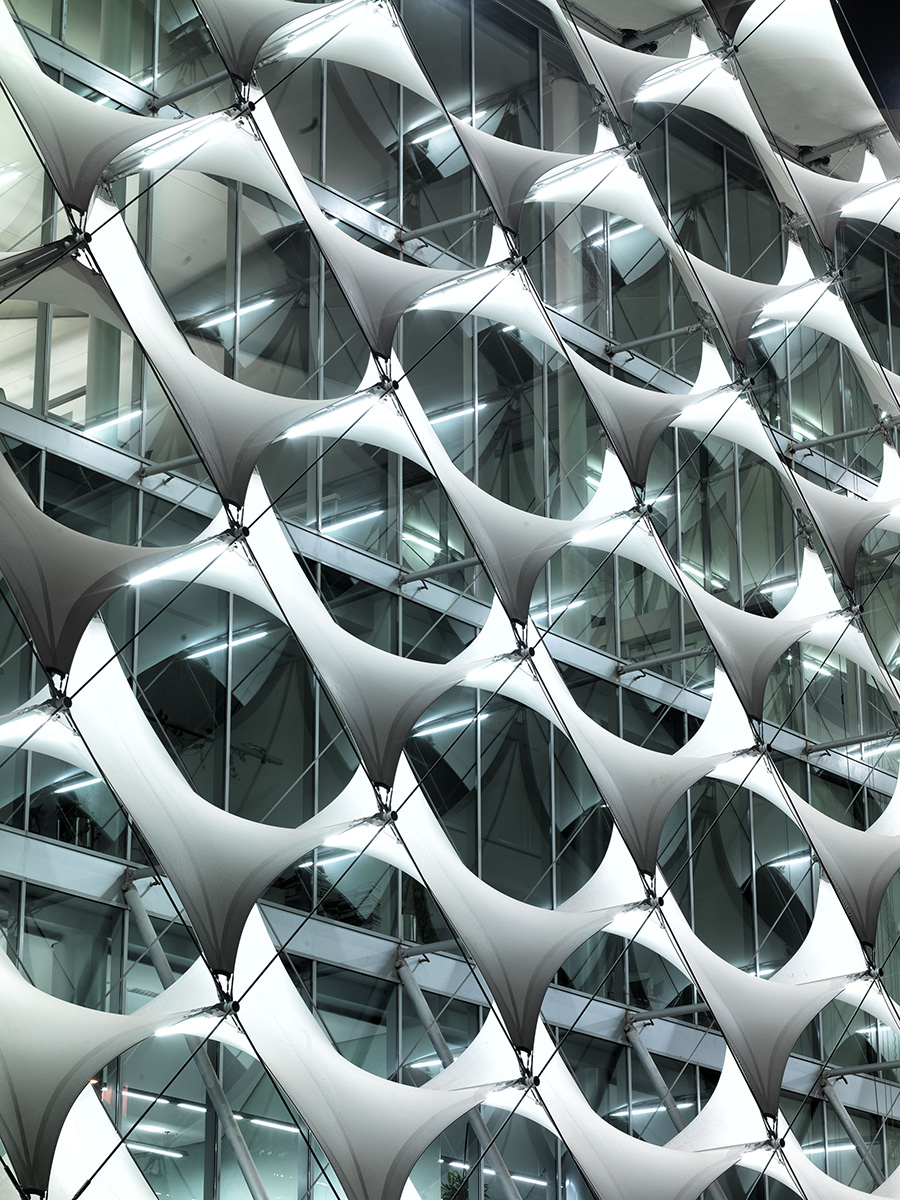 The key element of the facade is a cladding made up of rhomboid textile awnings, inserted white membranes and supported by a three-dimensional, tensile-stressed steel cable structure






