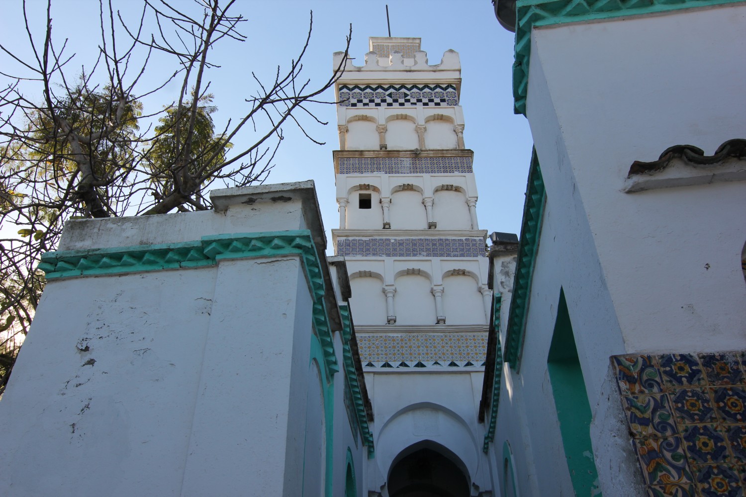 Low-angle view of the minaret showing levels of depressed arches and zellij frieze
