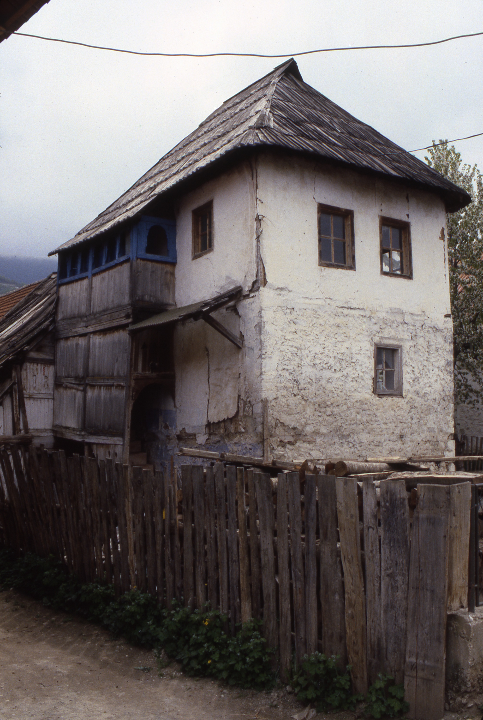 <p>This dwelling is typical of stone and wood frame construction that uses lighter infill to make exterior walls. The ground level is normally constructed above a masonry foundation used as a root cellar. Upper walls are constructed using lumber studs and areas between are filled with woven branches (wattle) and clay daub or soft brickwork. An exterior plaster coat was applied to seal the surfaces. The wood-enclosed stairs lead to the main living levels and gallery. One can see that the wood studs are notched to lock the finish surface to the wood frame. The wooden hipped roof is typical in the region.&nbsp;</p>