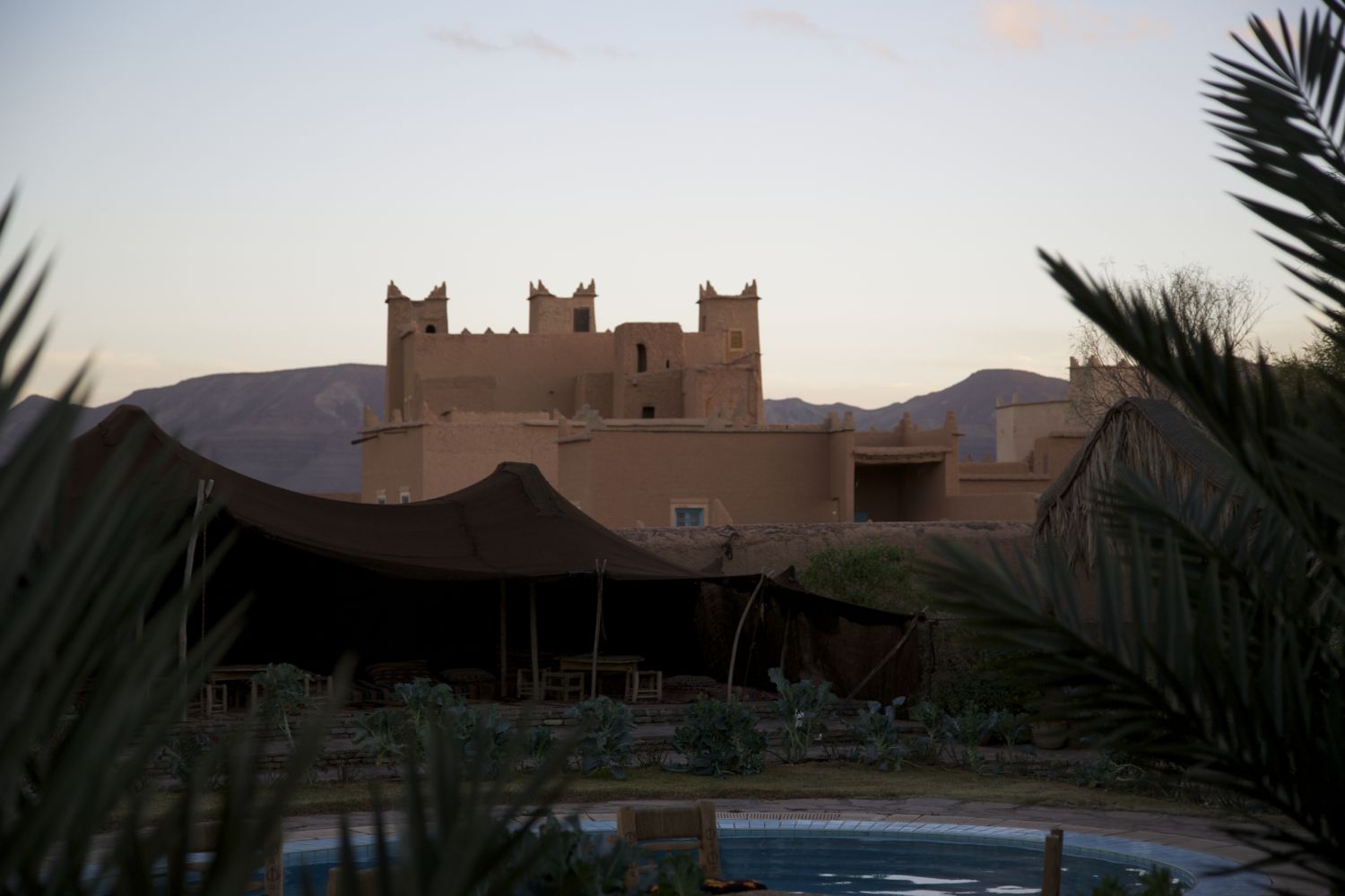 View over poolside tent beyond hotel grounds to other casbahs and the mountains