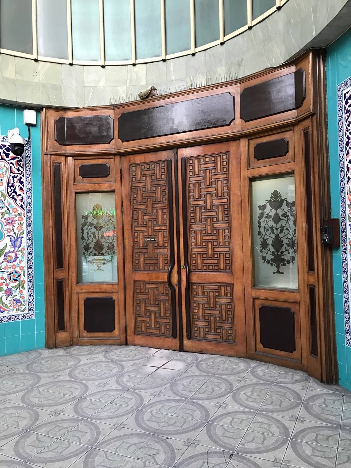 View of the carved wood doors and etched glass windows of the main entrance