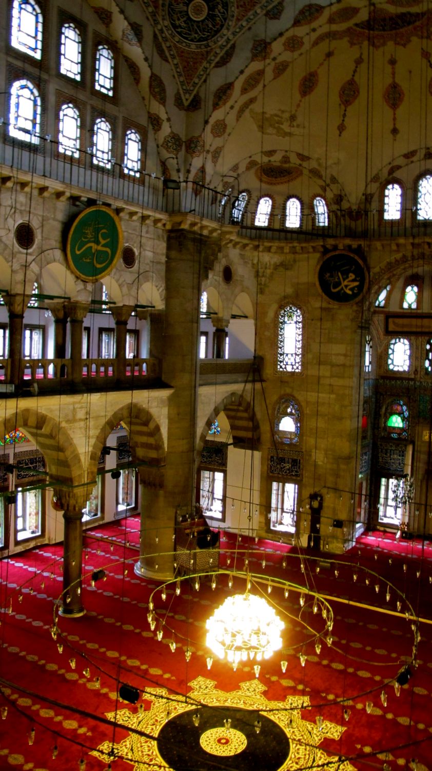 Interior view from gallery across prayer hall to corner, with the edge of the mihrab visible to the right