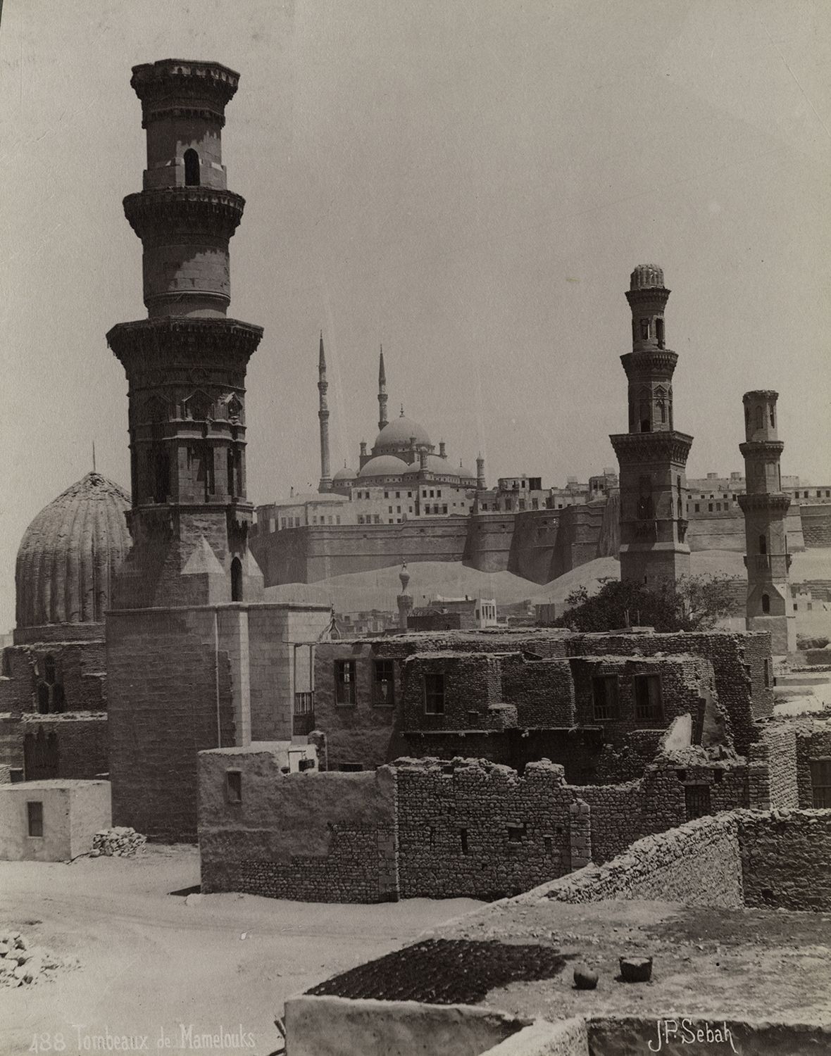 View of monuments in Cairo's Southern Cemetery. In the foreground is the minaret belonging to the Mosque of Amir Qawsun al-Nasiri. The two minarets in the background belong to the Sultaniyya Complex.