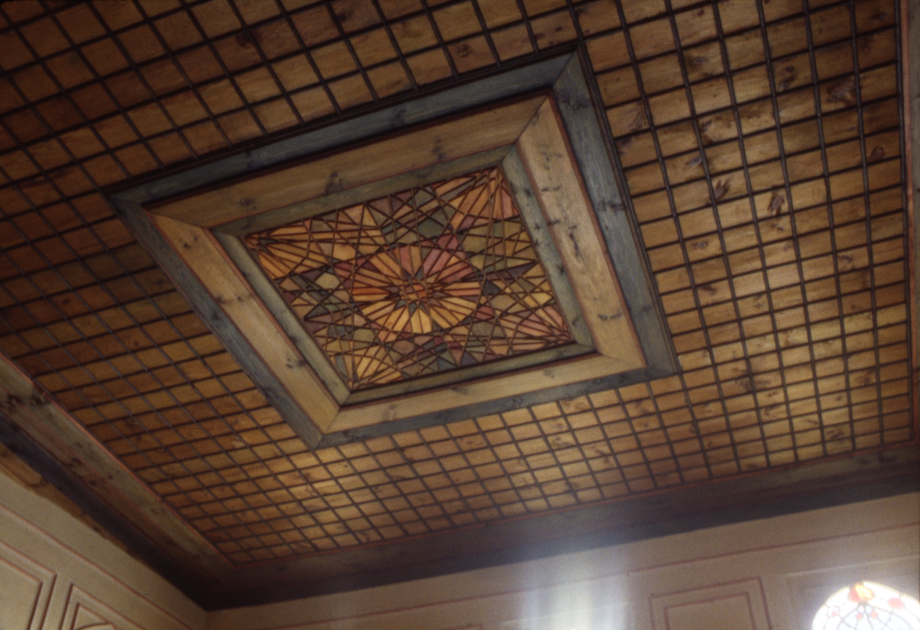 <p>The wooden ceiling of the kiosk area was constructed of panels, strips, and frames with a special center ornament. The ornament displays overlapping geometric shapes and stars that are formed through the use of grooves and a variety of colors applied to the wood. Center ceiling ornaments are present in many of the larger dwellings of the Ottoman and Bulgarian Revival periods.</p>
