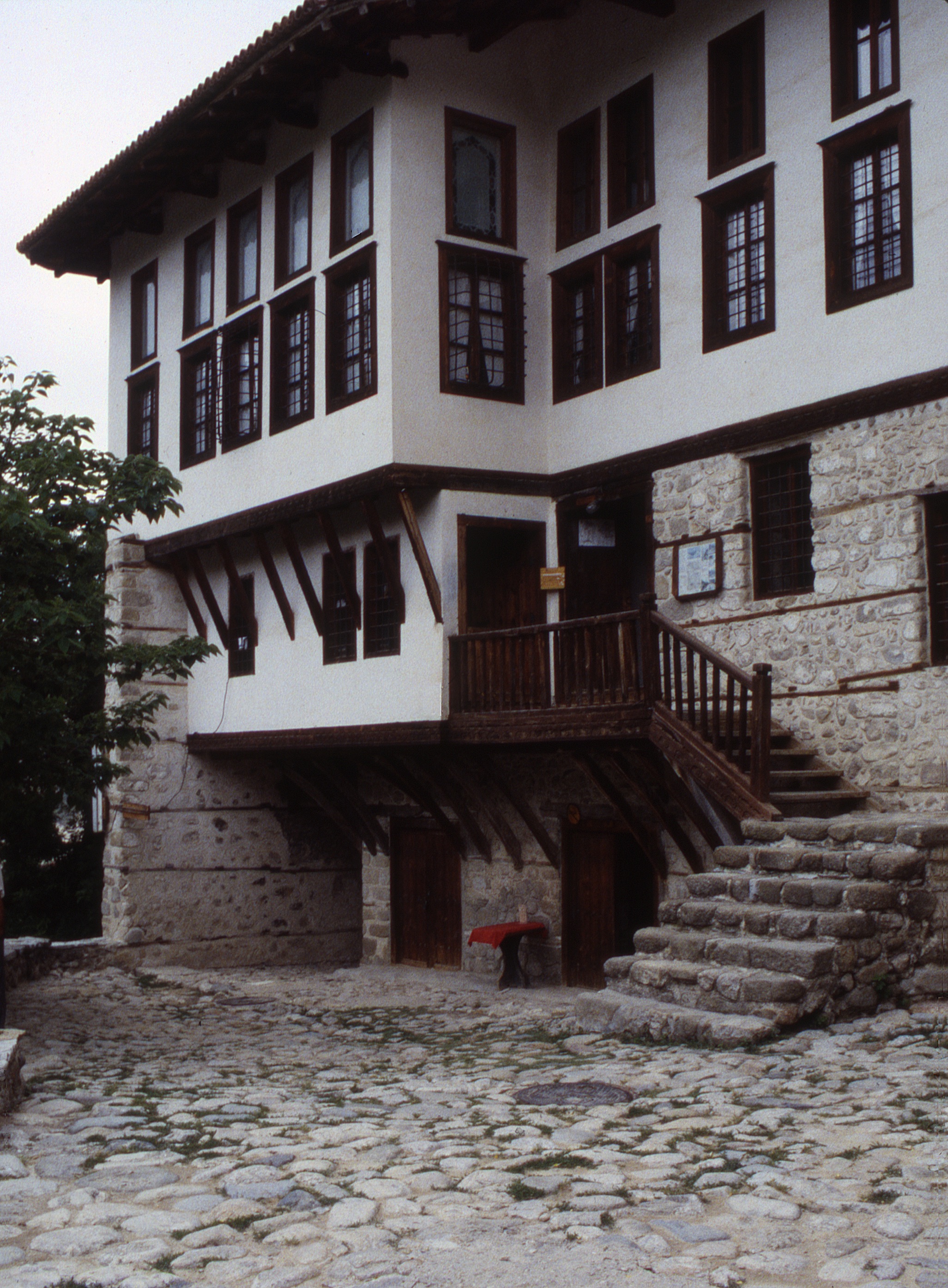 <p>The dwelling complex is designated as a historic object and currently serves as a museum. The covered area next to the stone wall at the left is a passage that leads to a gateway beyond. The ownership of the house passed from the Kordopoulos family to the Tsintsarov family and so is also known as the Tsintsarovata kăšta. The doubled windows on the upper floor are a feature of Greek Macedonian architecture, seldom found elsewhere in Bulgaria. Under the dwelling are caves and formed ventilated cellars to allow for the proper fermentation and curing of wine.</p>