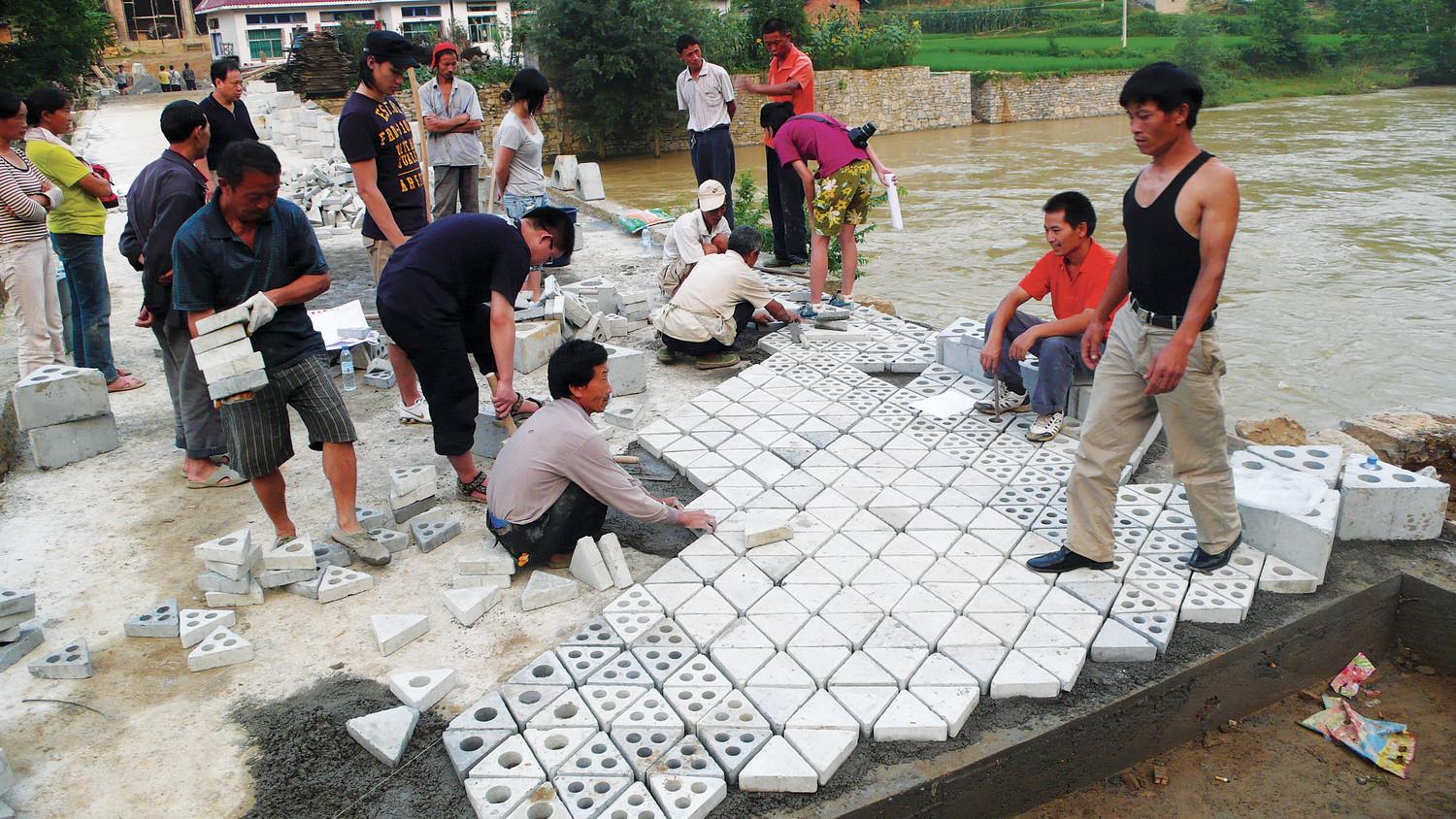 Villagers and students laying the pavers