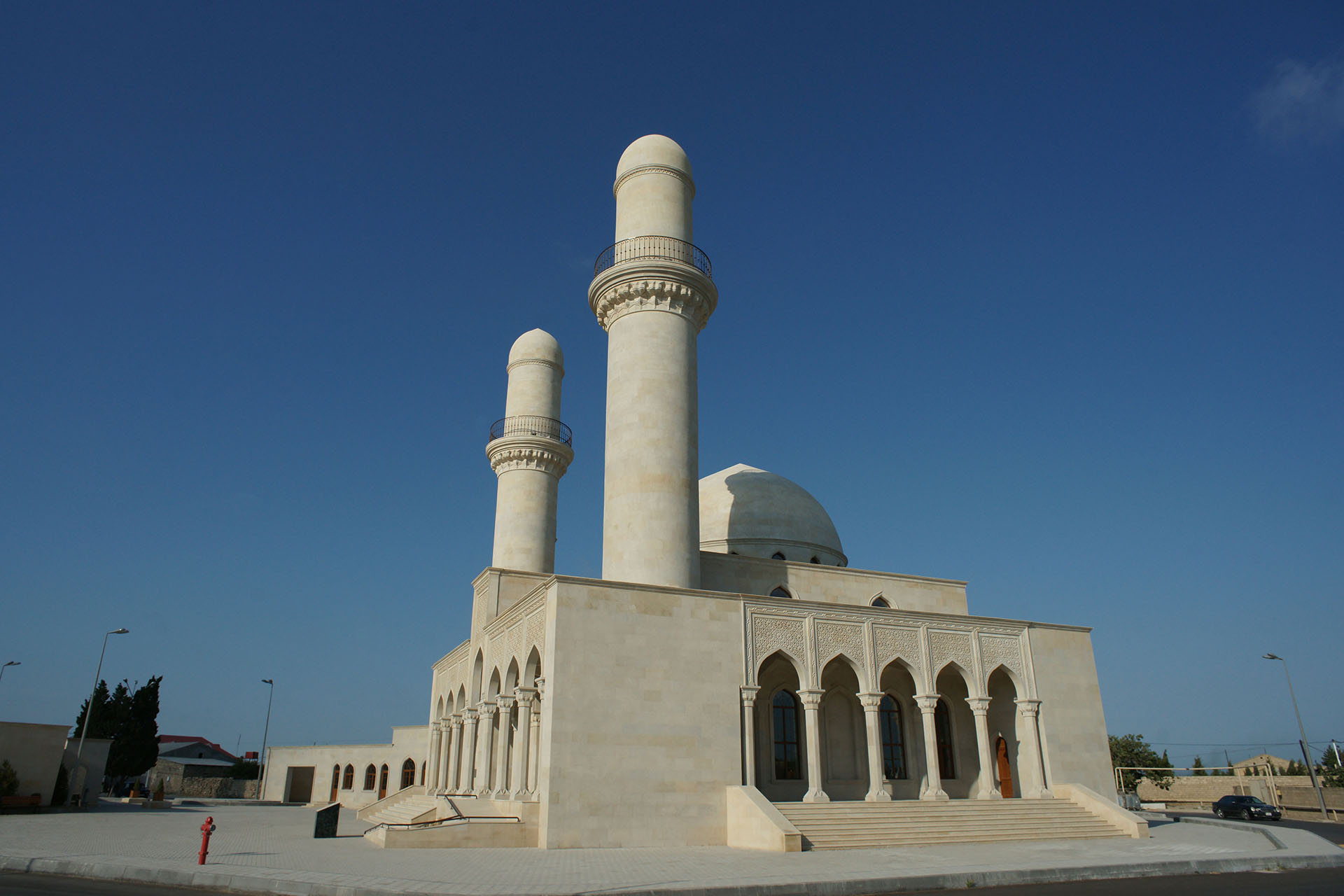 <p>Two minarets are located on either end of the double-arcaded entrance façade, and single arcades are located on both sides of the building, one of them providing access for women; ancillary buildings nearby contain separate ablutions facilities, a kitchen, offices, a library, and other facilities.</p>