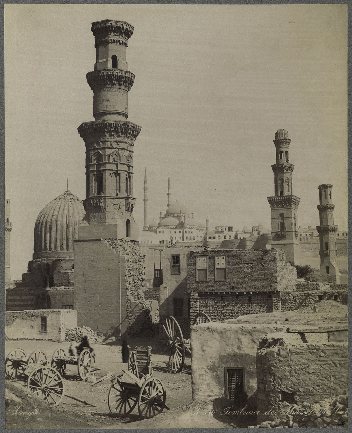 View of monuments in Cairo's Southern Cemetery. The minaret associated with the Mosque of Amir Qawsun al-Nasiri is visible in the foreground. The minarets of the Sultaniyya Complex are visible in background.