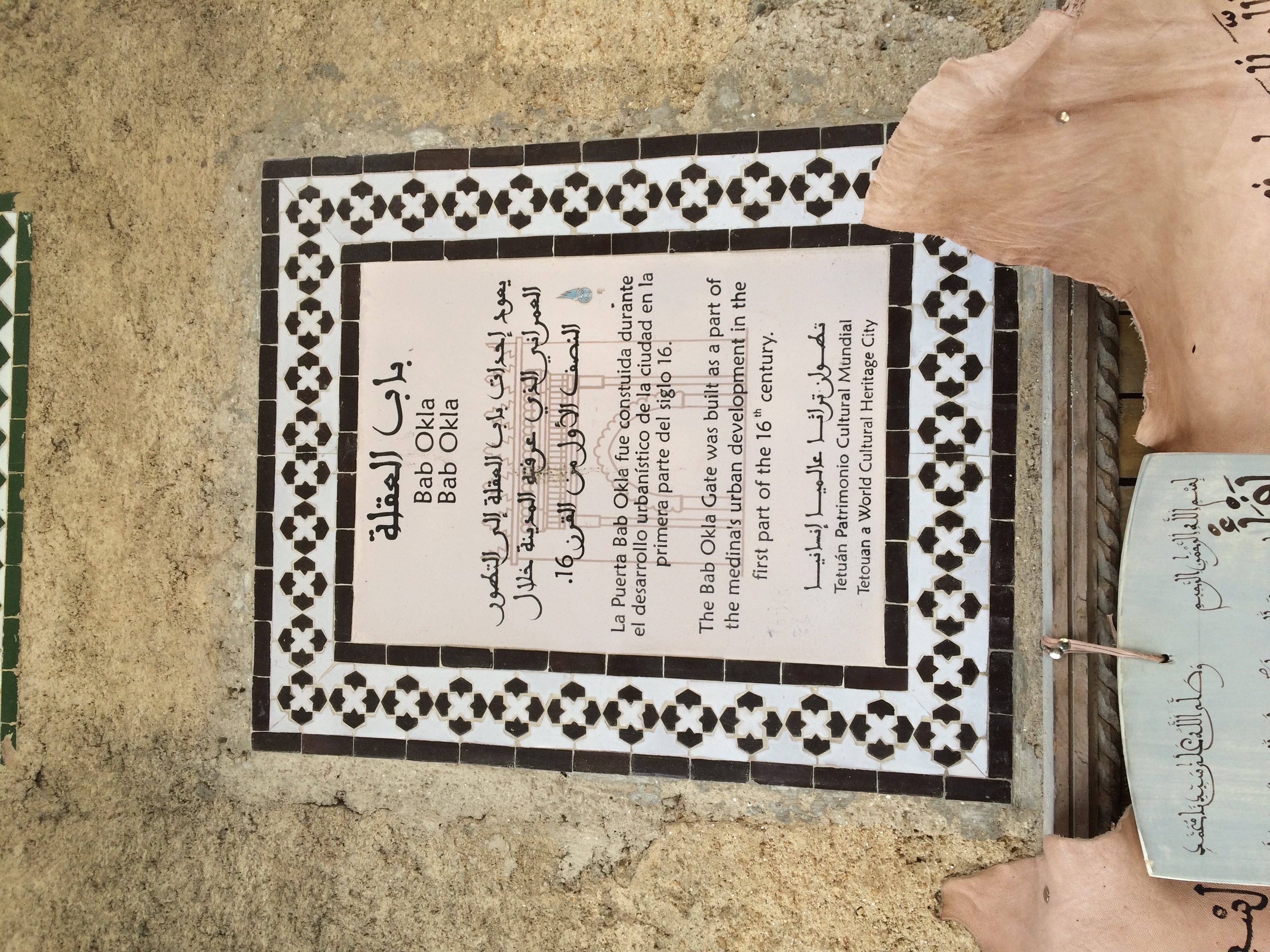 <p>A glazed tile sign in Arabic, Spanish, and English indicating when the gate was originally constructed.</p>
