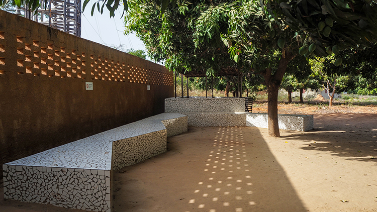 <p>Outdoor seating shaded by a large tree.</p>