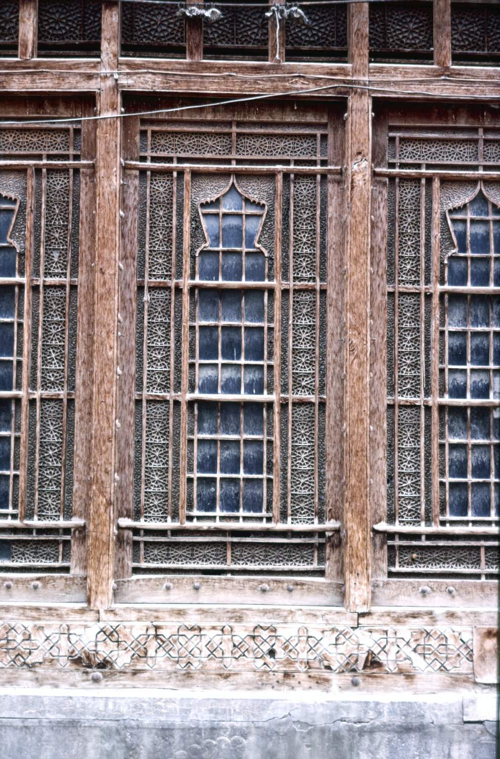 Detail of lower half of wood-framed windows of main reception room overlooking courtyard on north side, from exterior. 