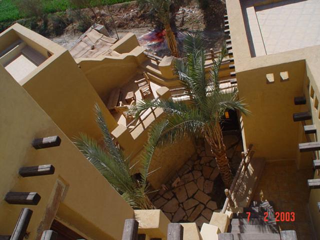 A bird's eye view photo of the back patio illustrates the irregular architectural style, used all along, that gives the building a sense of unique beauty.