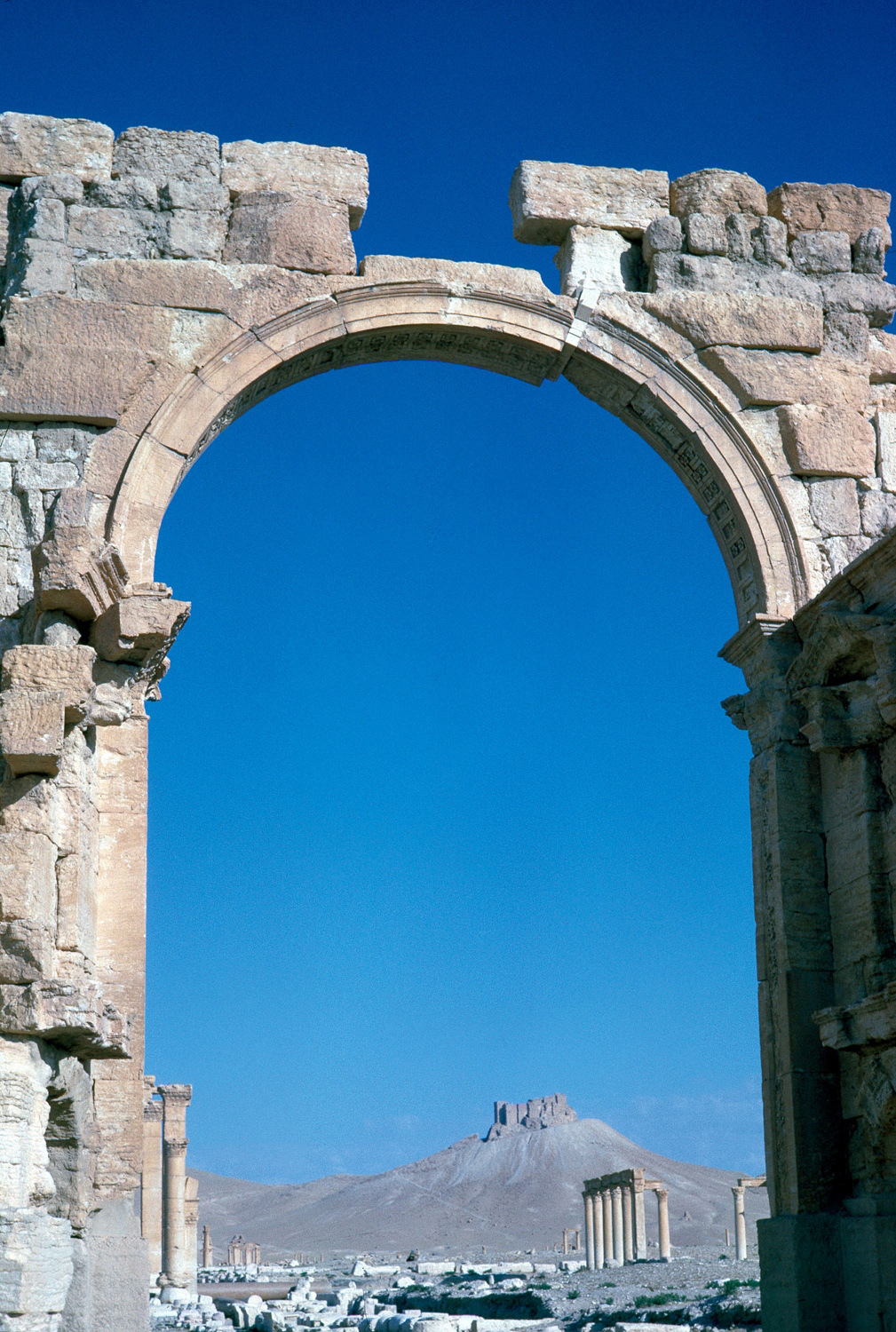 Detail of an arch of the Great Colonnade, with the Qala seen in the distance through the arch. The arch was reported destroyed in October 2015.