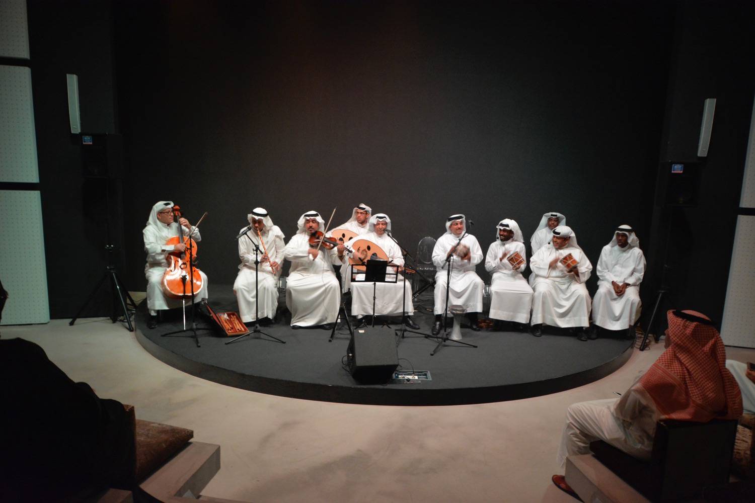 Interior view of the performance space in the Mohammed Bin Faris House, with a band performing on stage.