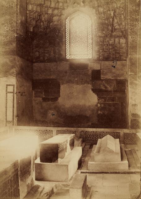Interior view of the cruciform-shaped funerary chamber showing an axial alcove with light pouring in from an arched wooden opening with interlacing geometric design