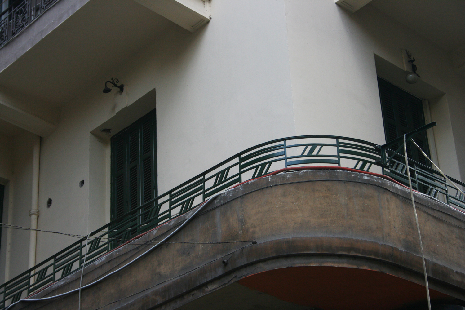 Detail of the horizontal balcony with rounded edge and geometrical wrought iron forms