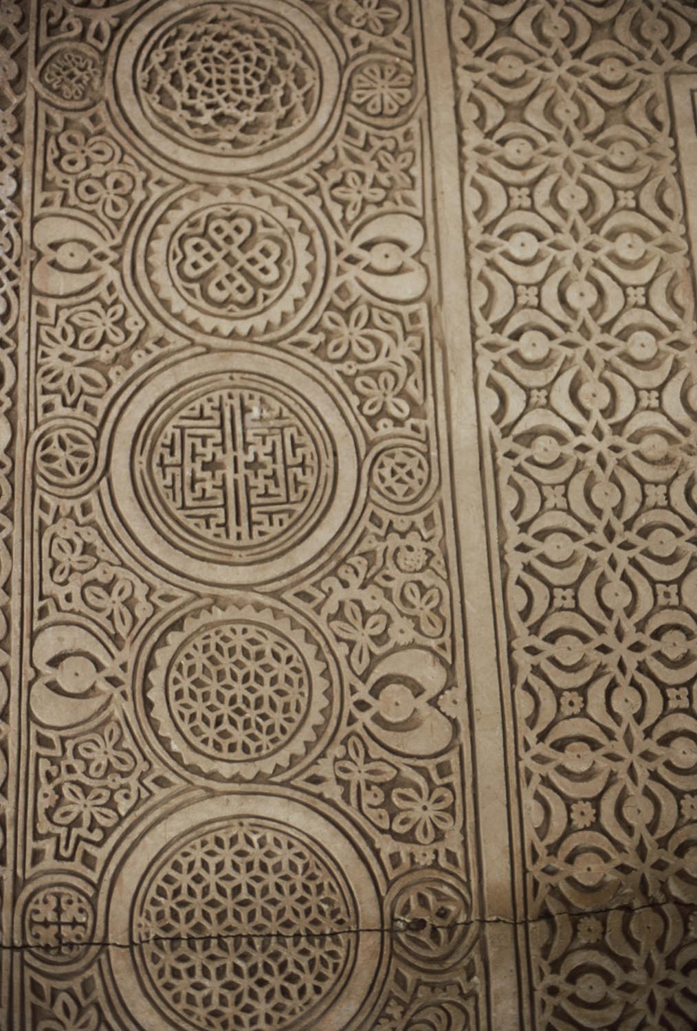 Detail view of mihrab, showing carved stucco roundels filled with geometric patterns.
