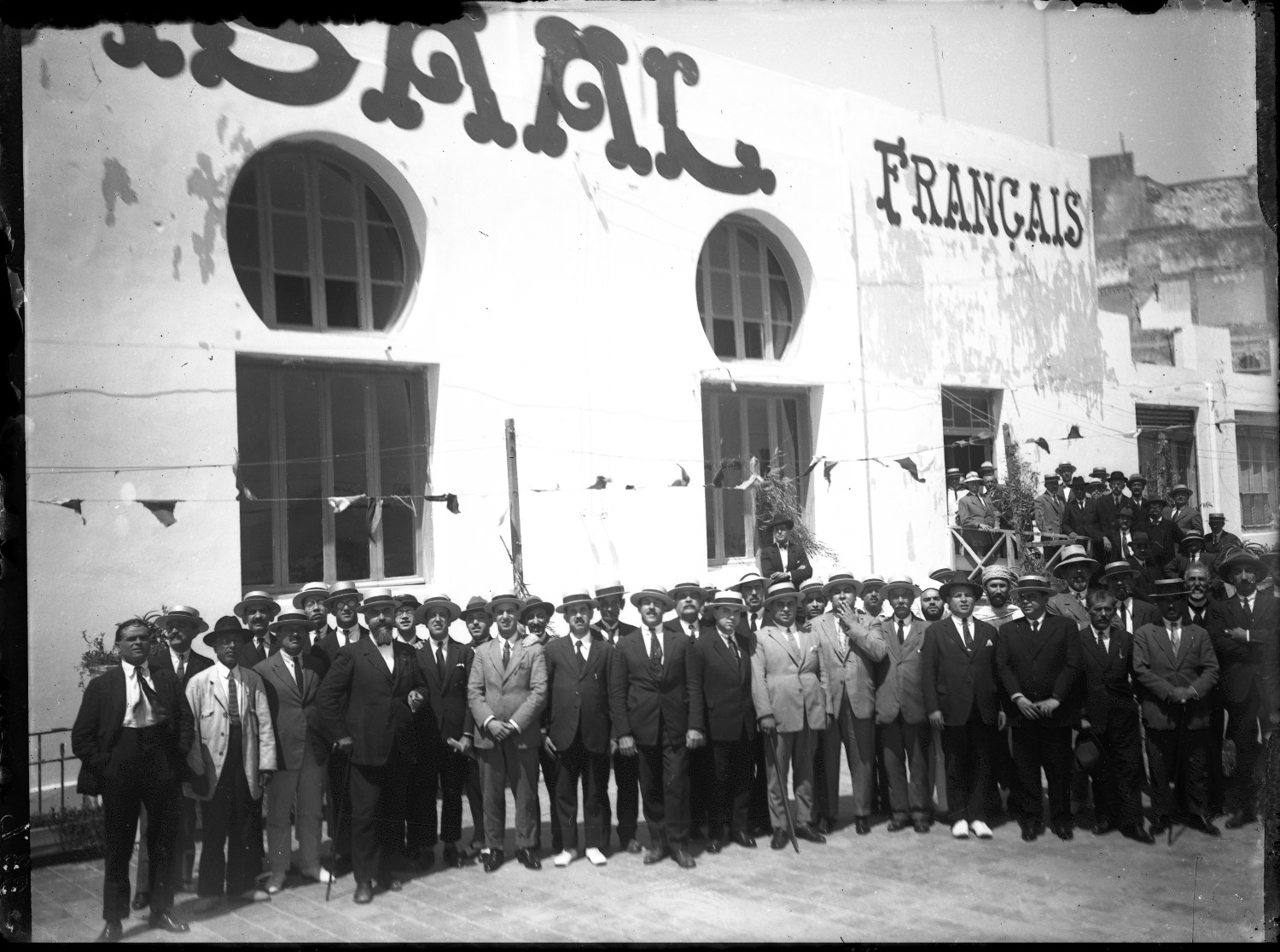 Large group of men, in European dress, outside of Kursaal Francais