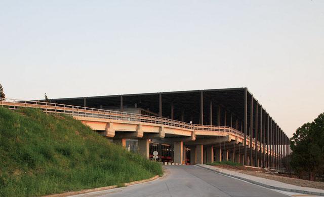 Side view showing the airport access bridge, and the floating steel cover constructed from standard profiles on a concrete-framed structure