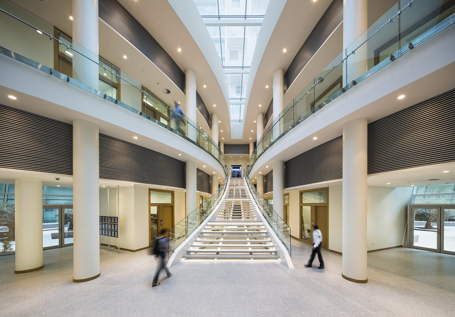 The Experimental Research Building is a two-story structure organised around two courtyards flanking a central stair. A skylight above the stair floods the double-height lobby with light. Offices face the courtyards, which are visible to the left and right from the moment of entry  