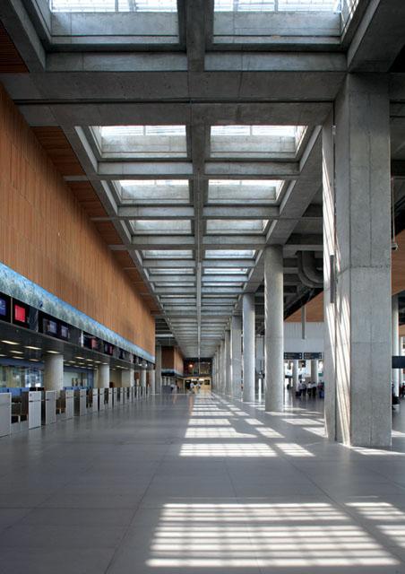 Departures entrance. Instead of shiny materials and glittering forms, exposed concrete, natural wood and matte facing were used on the dark surfaces