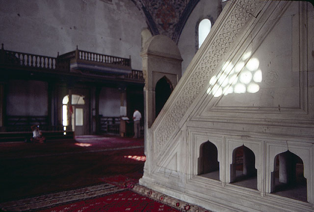 Interior view showing the minbar and the wooden balcony for women, with red Thracian carpets in the foreground
