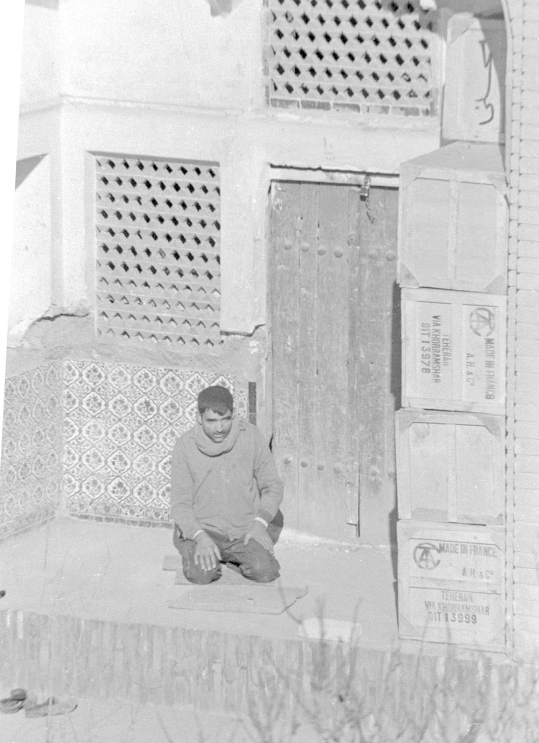 Man praying within the arched entrance to one of the cells surrounding the courtyard.