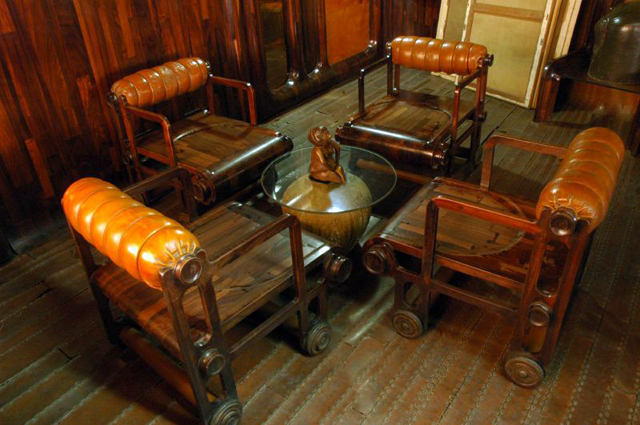 Interior view of the informal seating area , depicting furniture designed by Nari Gandhi: wheeled metal chairs  with wooden seats and leather cushions. The walls are clad with thin redwood strips; likewise, the floor is carpeted in thin strips of leather, stitched together