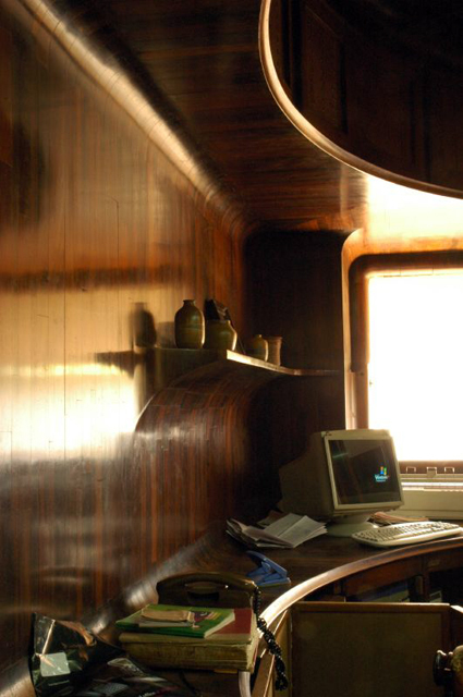 Interior view of the staff area, showing redwood-clad walls with a projecting shelf, a curved loft above, and a built-in work surface