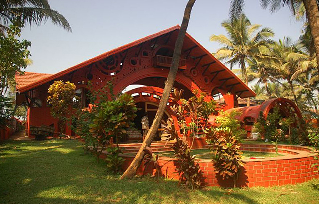 Exterior view of sea-facing elevation of bungalow; the barrel-vaulted bedrooms are visible in center and at right. Under the main roof of the bungalow is the arched pavilion