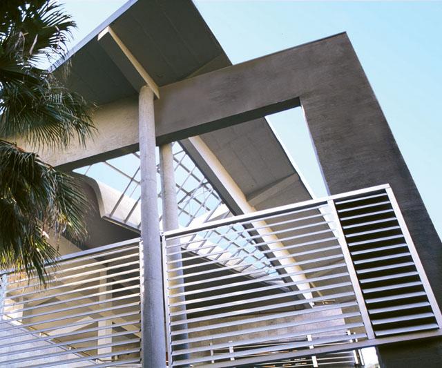 Projecting roof in concrete with aluminum louvers