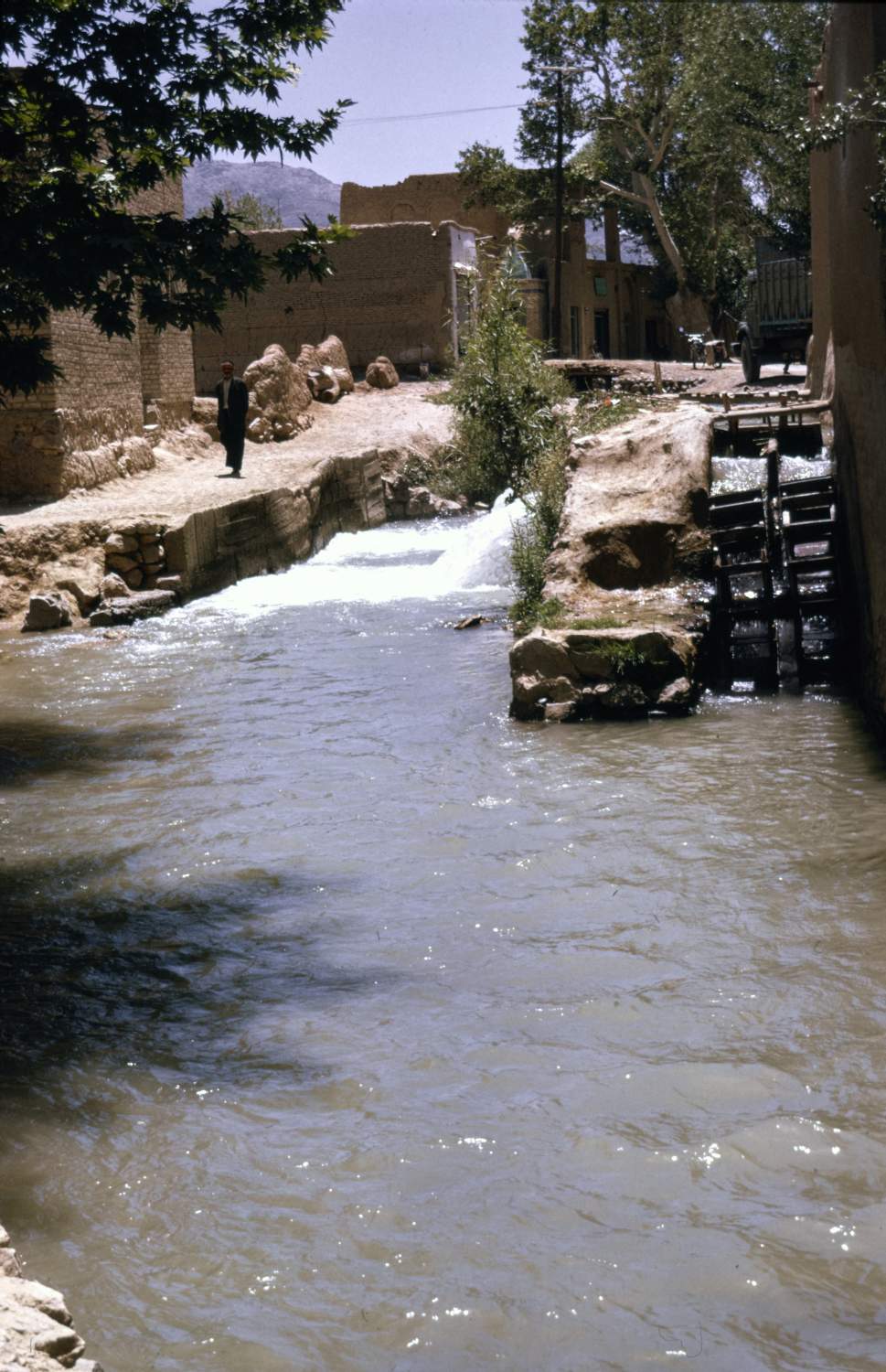 View of unidentified canal and wooden waterwheel in Isfahan