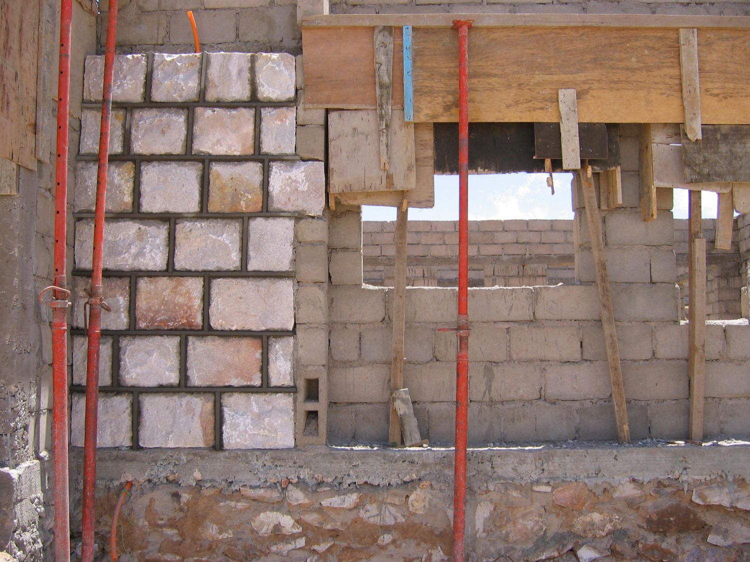 View of a wall under construction.  Cinder blocks were formed on site.