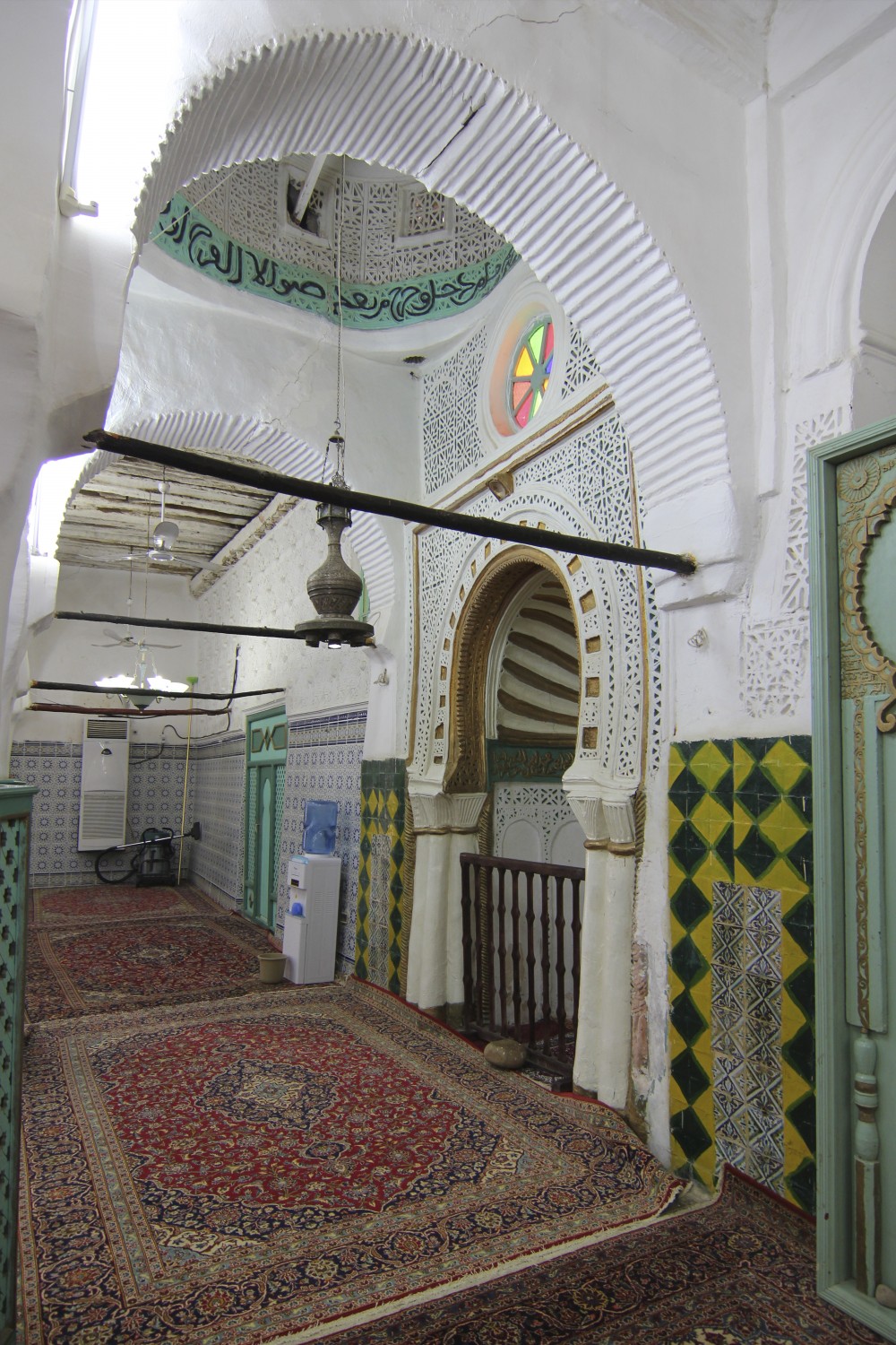 View of the qibla wall showing mihrab and dome, and palm trunk ceiling