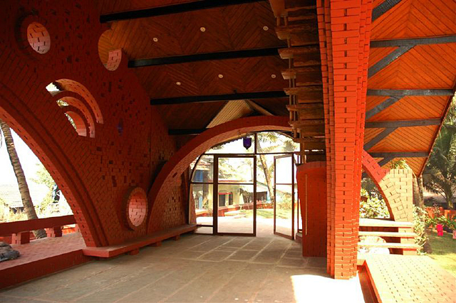Interior view taken from within the pavilion, looking at the roof with its steel rafters supporting the wooden layer of the mangalore-tiled roof