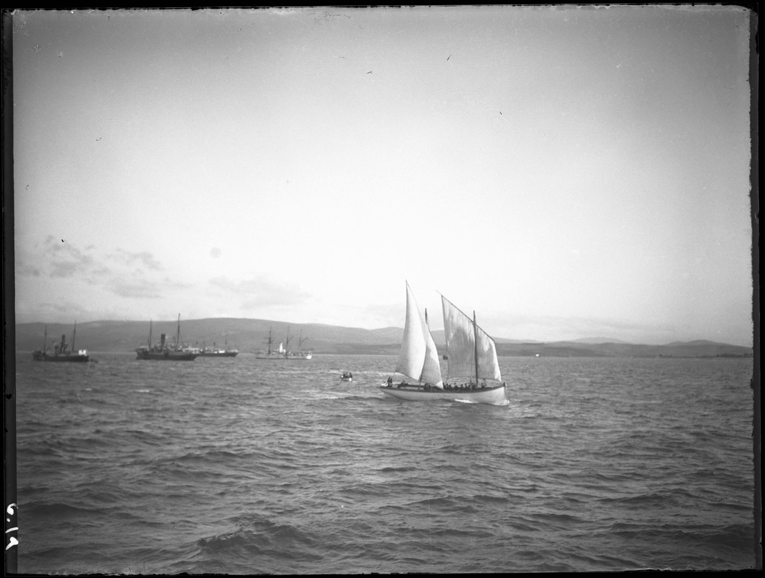 A number of ships, sailboats, and rowboats on the water