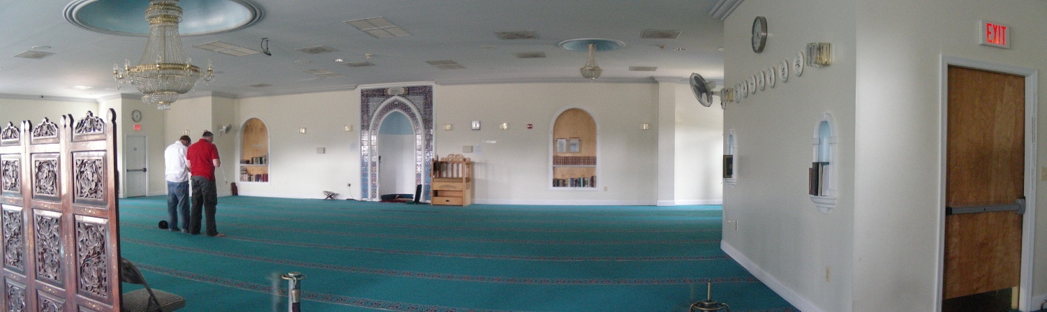 Panoramic view of prayer hall, looking towards the qibla wall, with two men praying