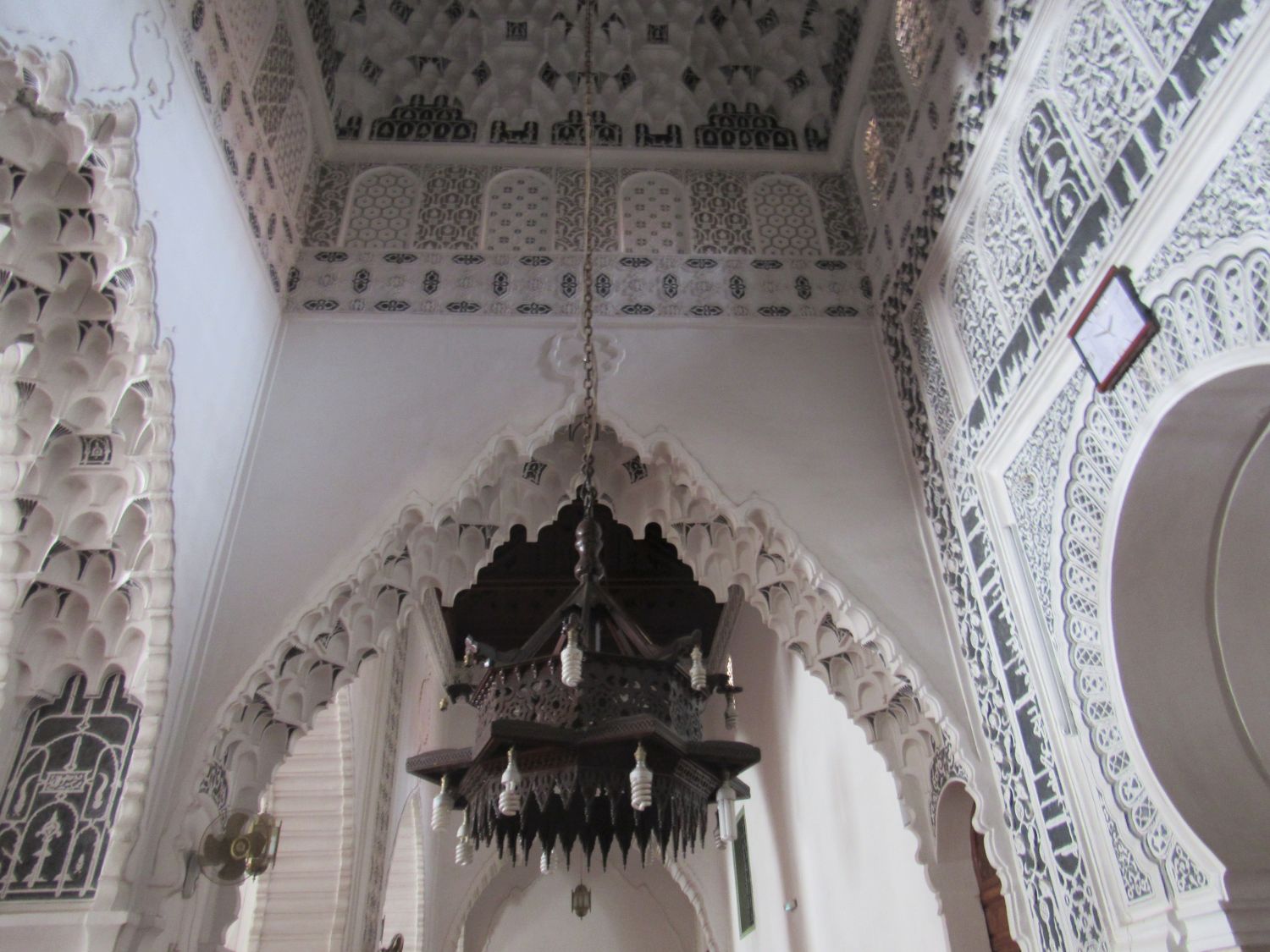 Interior view, chandelier and the muqrnas embellished ceiling and archeways of the mihrab bay, painted in black and white.
