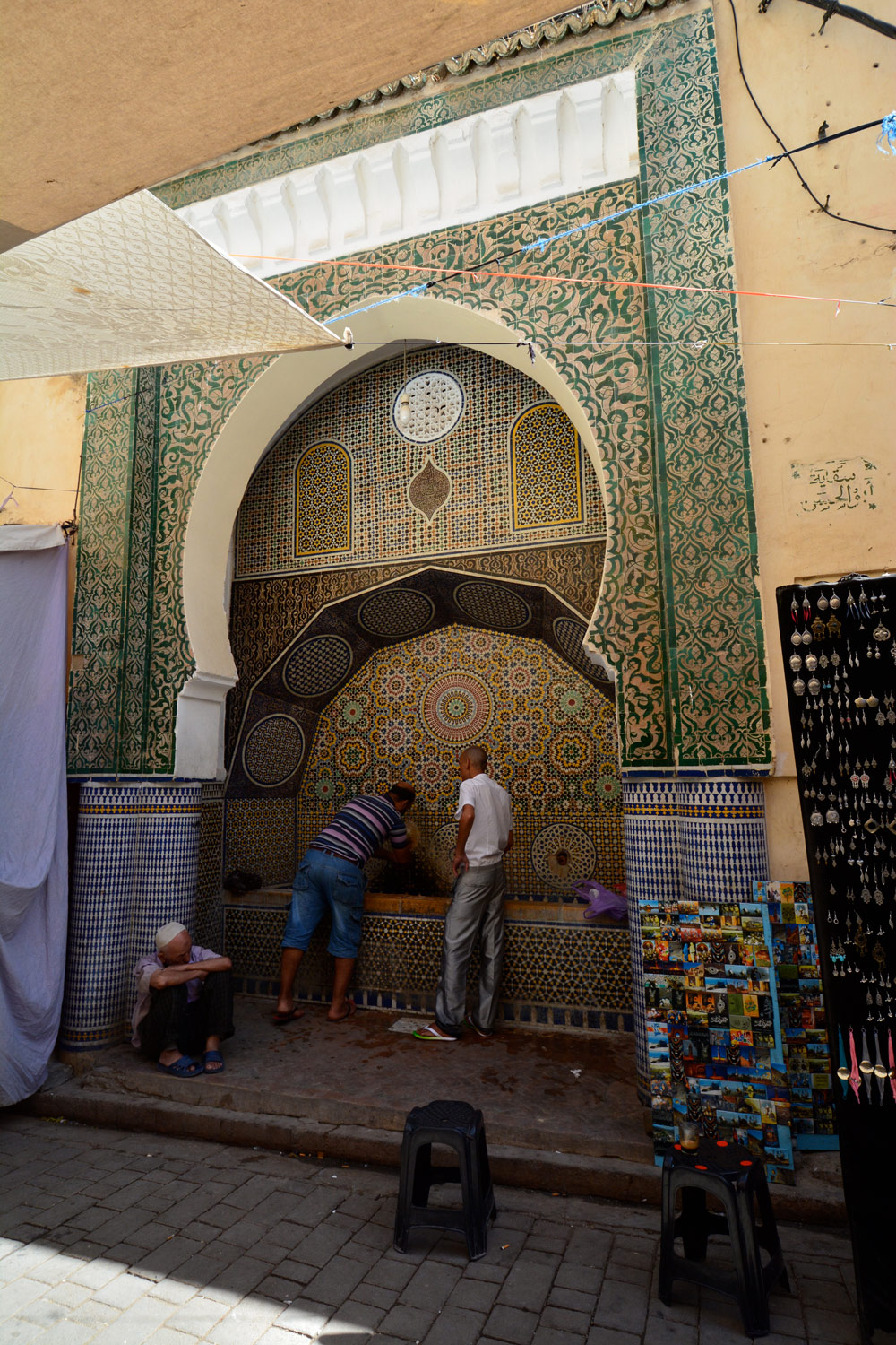 A public water fountain inset in a tiled niche inside Bab Bu Jallud.
