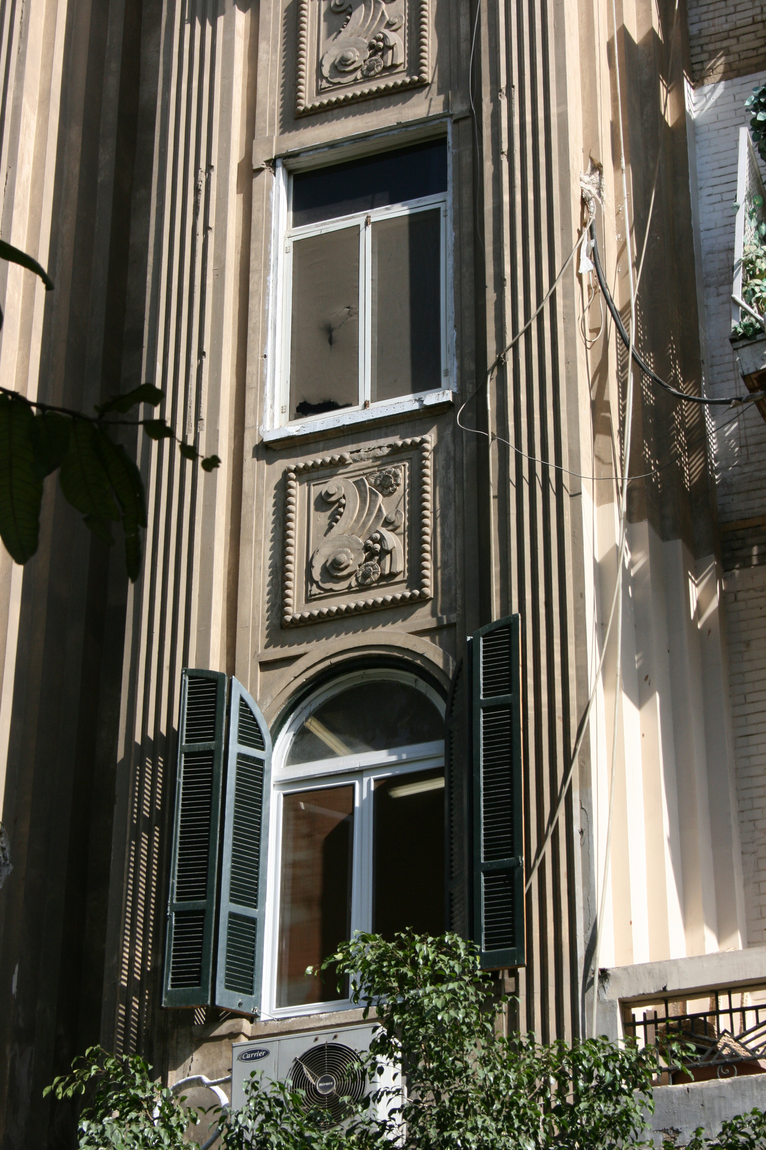 Detail of the "avant-corps" with the box sections and a brunch of stylised flowers in stucco