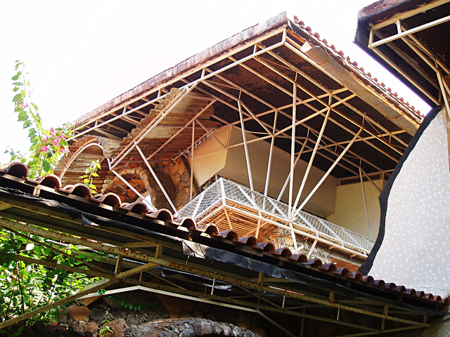 Exterior view looking upwards at the entrance facing balcony and mangalore-tiled roof