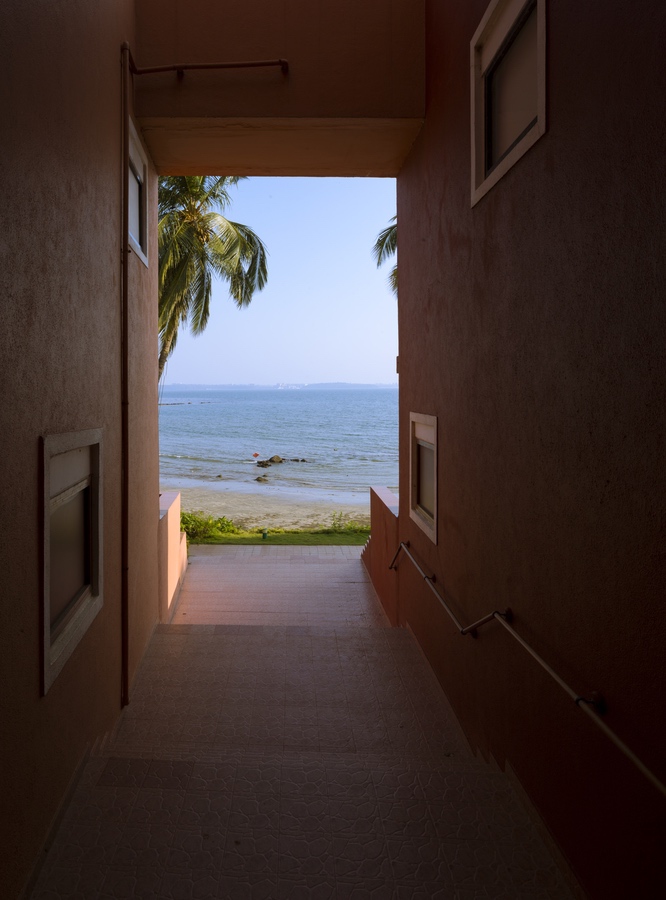 <p>A corridor between the rooms leading to the sea</p>