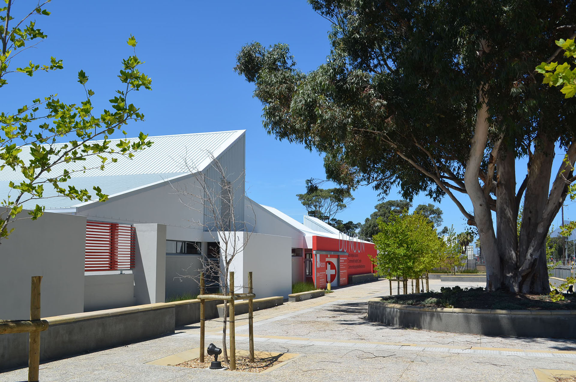<p>Public forecourt with existing tree and seating. This new health facility provides for the needs of the community of an overcrowded informal settlement where people live in extreme poverty conditions on the fringe of metropolitan Cape Town.</p>